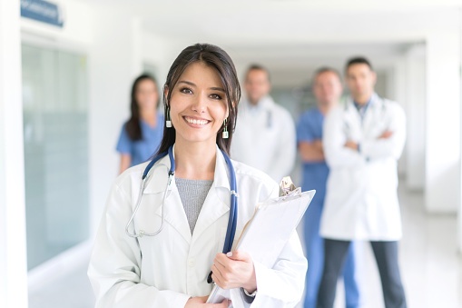 Smiling-female-physician-w-group-510412702